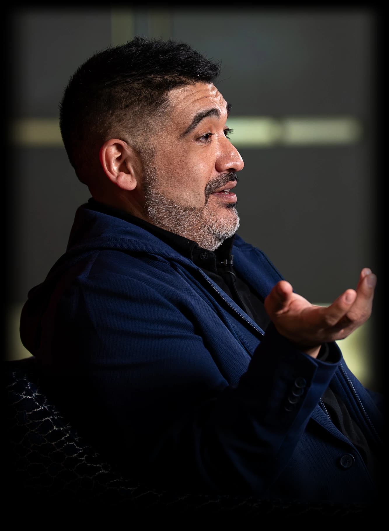Miguel Carrasco seated in an armchair, talking with his hand raised